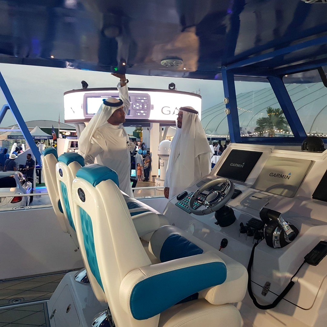 Two Emirati men inspecting a boat cockpit at a boat show