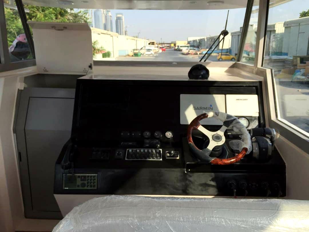 Boat helm with wood-trim wheel, Garmin and Mercury controls