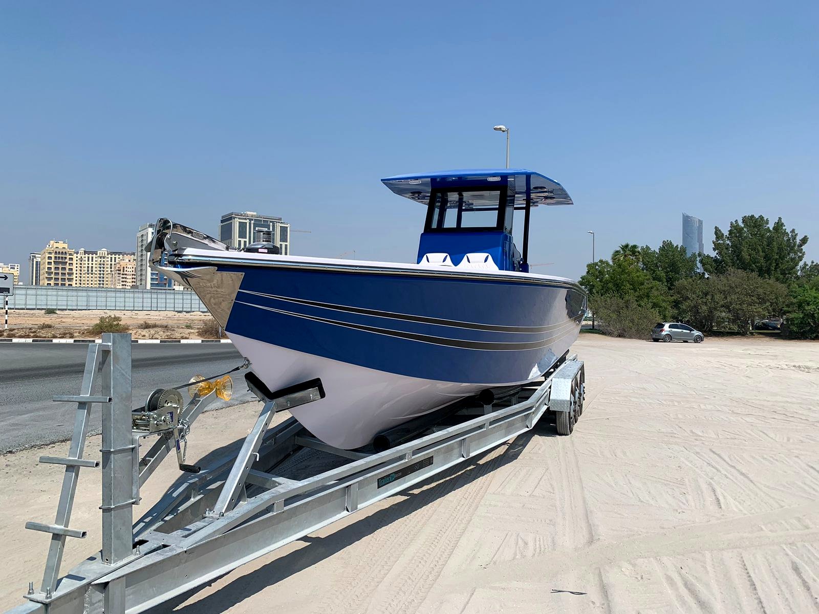 Blue and white center console boat on trailer with UAE backdrop