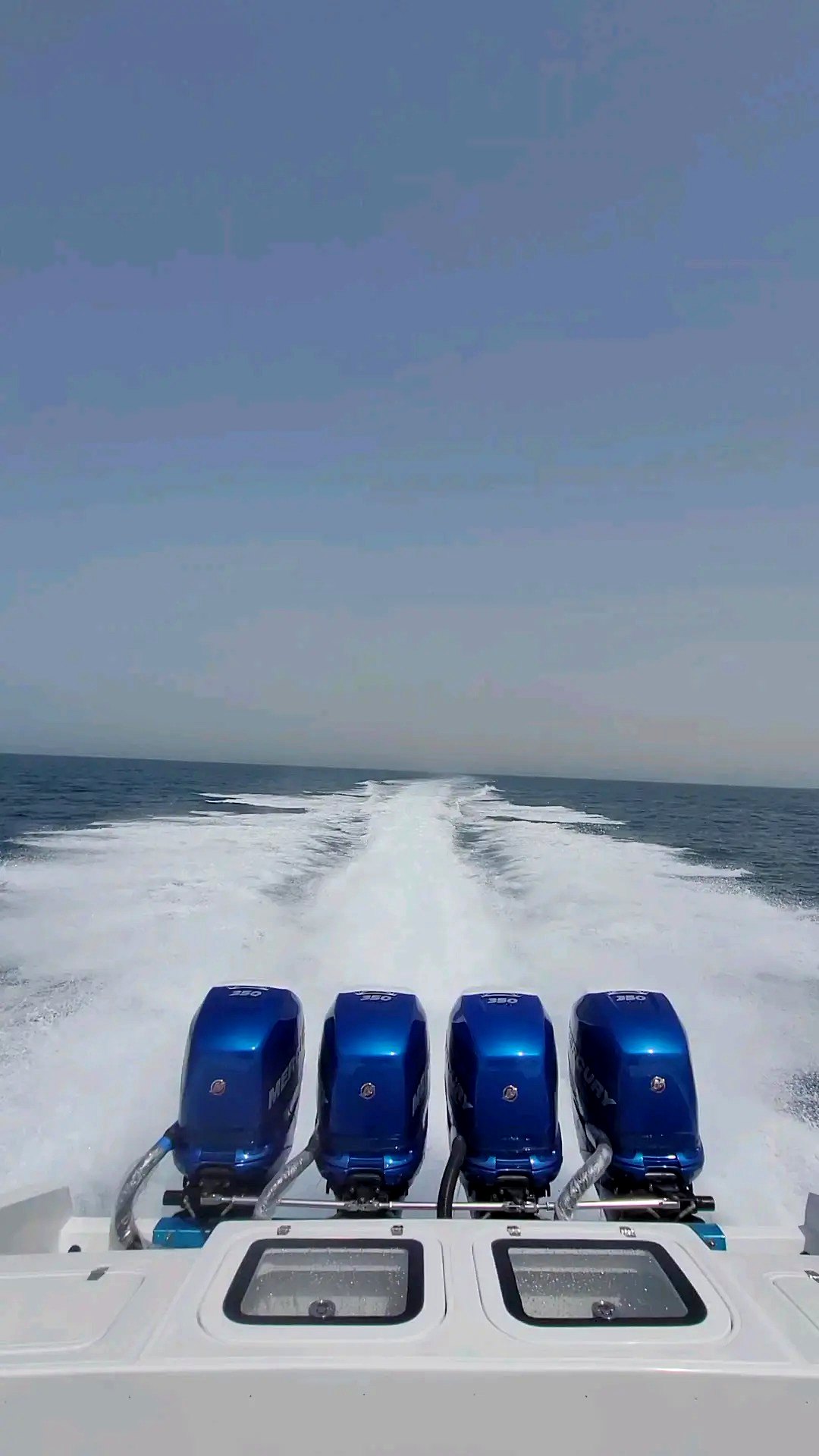Looking back at four Mercury 350 outboards and the wake of a boat at speed
