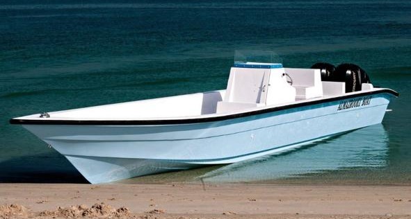 White open fishing boat with twin outboards drawn up on a Gulf beach