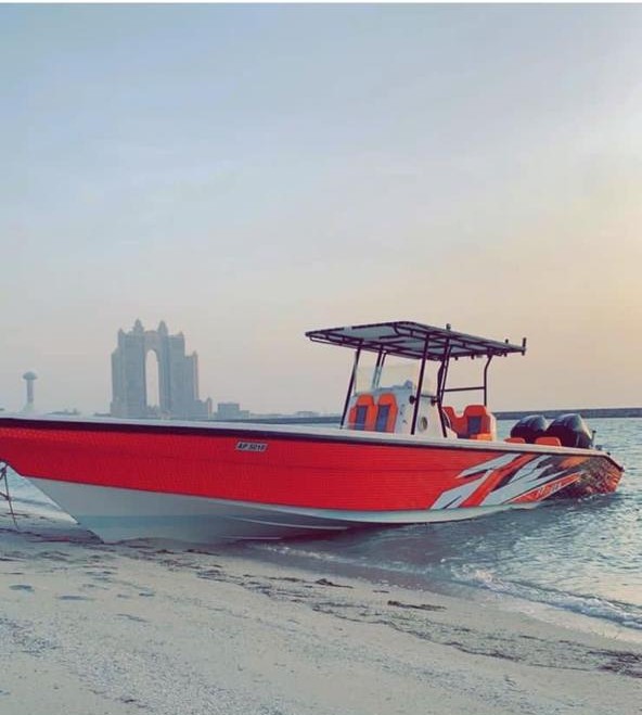 Red sport center console with T-top beached at sunset off the Abu Dhabi shore
