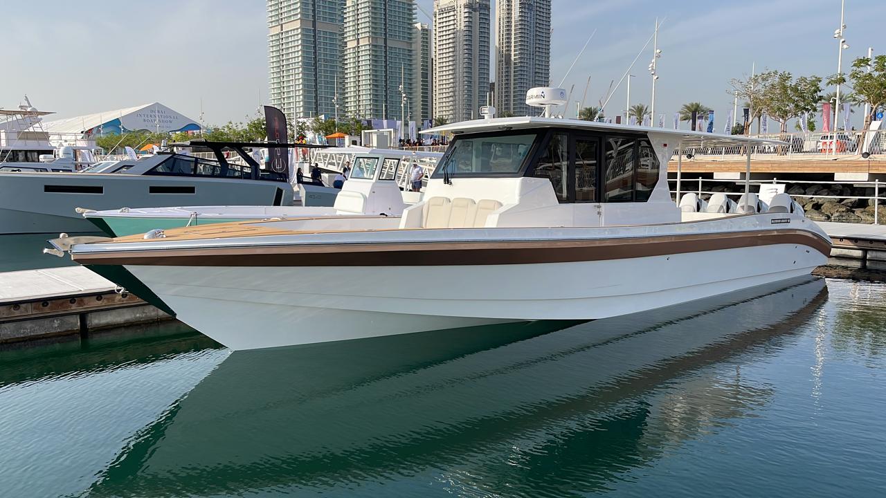 White walkaround cabin boat with teak sheer stripe berthed at the Dubai International Boat Show